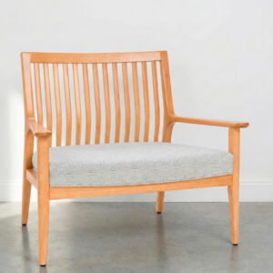 Butacón Olsen Nature de madera clara con tapizado gris claro en un ambiente minimalista con luz natural.