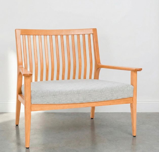 Butacón Olsen Nature de madera clara con tapizado gris claro en un ambiente minimalista con luz natural.