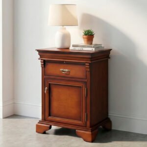 Mesa de luz clásica modelo Versalles de madera color cedro con detalle de sombreado, un cajón superior y puerta inferior sobre fondo blanco.