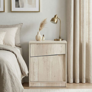 Mesa de luz modelo Kendor fabricada en melamina Helsinki de color madera clara, con un diseño de frente geométrico y líneas oblicuas, ubicada en un dormitorio de estilo nórdico y tonos neutros.