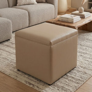 Puff cúbico cerrado de 50x50x50cm tapizado en piel sintética beige claro, con costuras decorativas y patas negras, sobre fondo neutro.