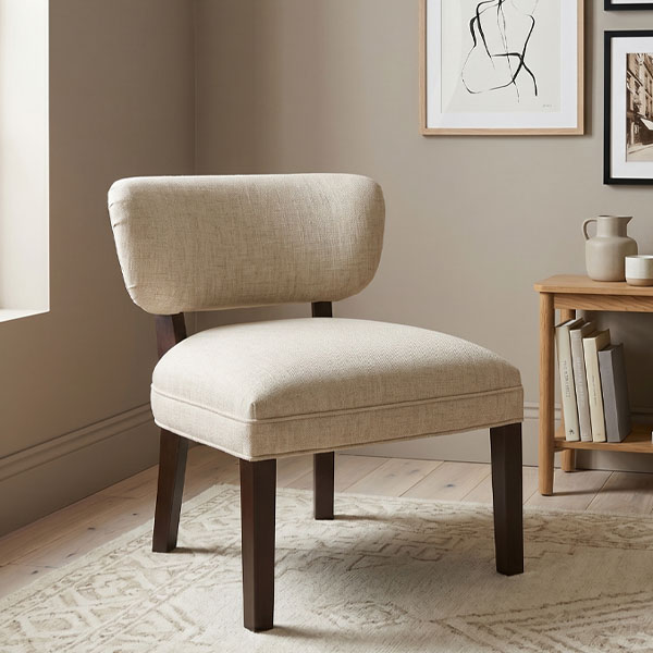 Sillón Bali de diseño nórdico fabricado en madera de guatambú con tapizado en tela color beige sobre fondo blanco.