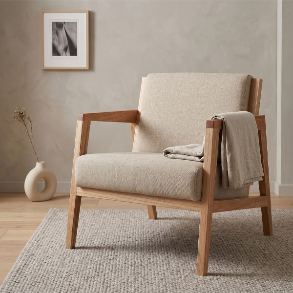 Sillón individual modelo Daven con estructura de madera maciza de paraíso en tono natural y tapizado en tela color beige, diseño de estilo escandinavo con líneas rectas sobre fondo blanco.