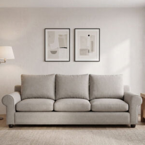 Sillón de 3 cuerpos tapizado en tela de color gris oscuro, ubicado sobre una alfombra tejida en un acogedor ambiente de sala de estar.