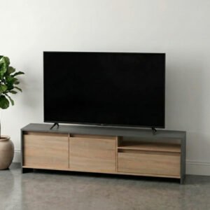 Mueble rack para TV de madera clara con estructura gris oscuro, ubicado en una sala con piso de microcemento, pared blanca y decoración con planta y lámpara de pie cálida.