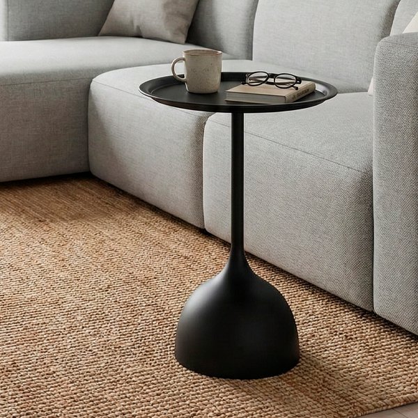 Mesa lateral redonda de metal negro mate con base en forma de gota y tapa tipo bandeja.