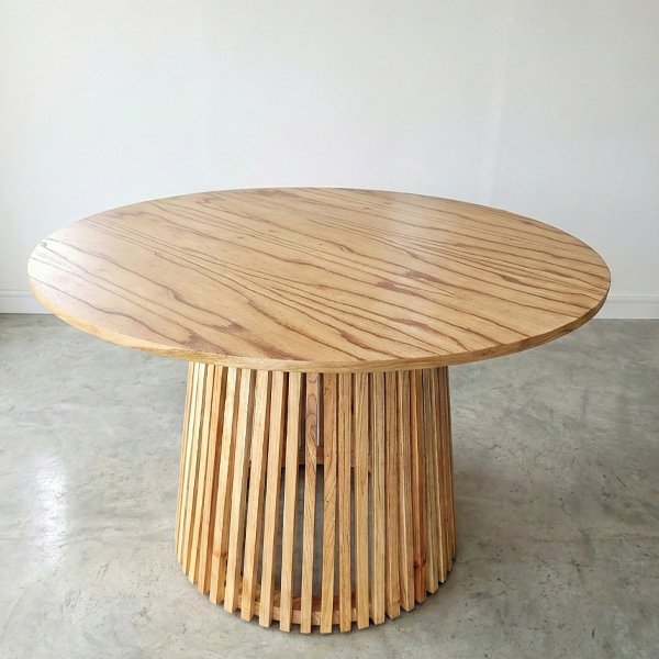 Mesa redonda Amazona de madera paraíso con base cilíndrica de varillas verticales de diseño moderno.