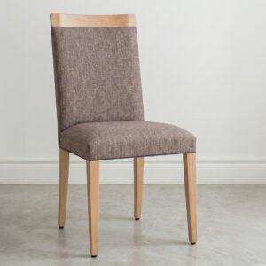 Silla de comedor modelo Dente fabricada en madera maciza de guatambú con asiento y respaldo tapizados en tela color visón, ambientada en un espacio moderno con luz natural.